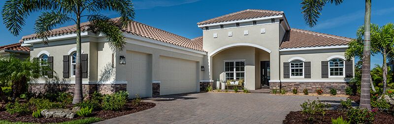 Completed Sam Rodgers home exterior with paver driveway and palms