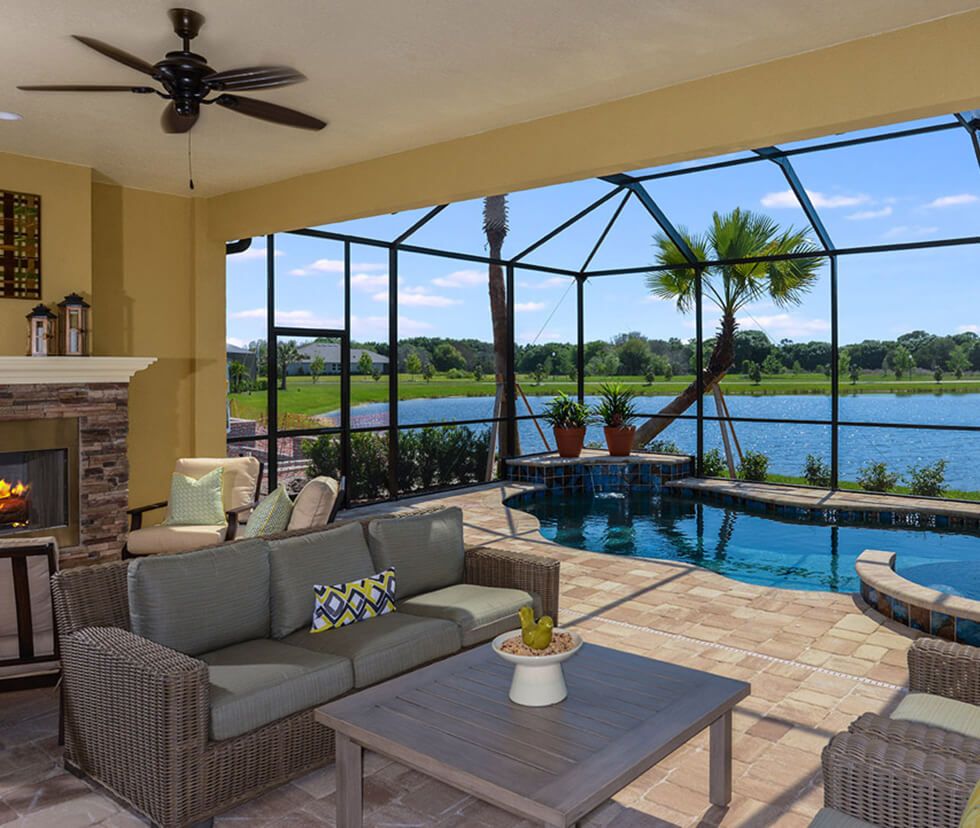 Screened lanai with pool, fireplace, and lake view