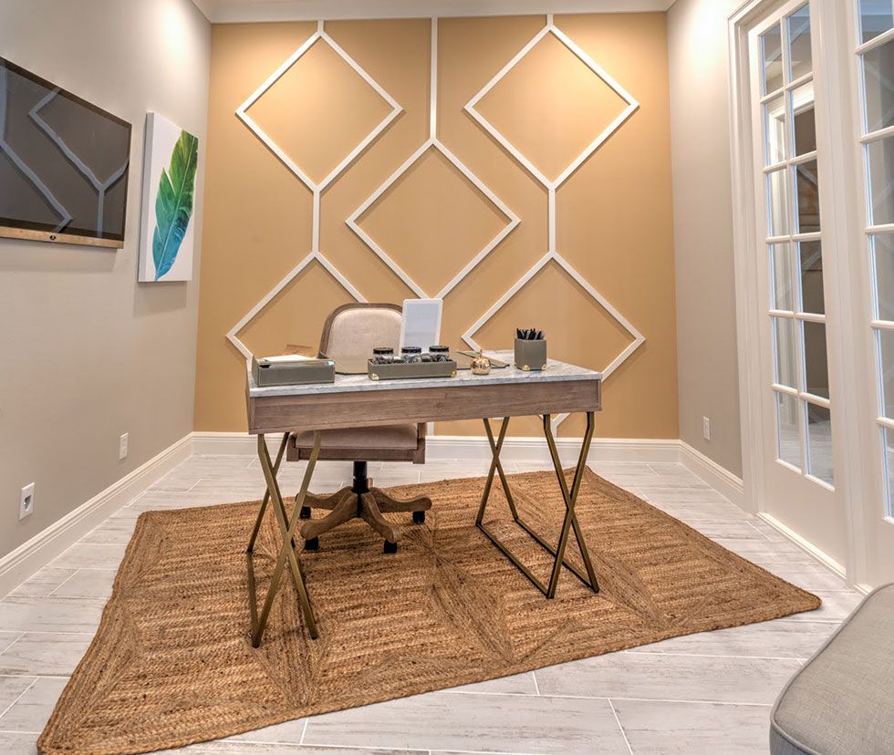 Home office with geometric trim accent wall and desk