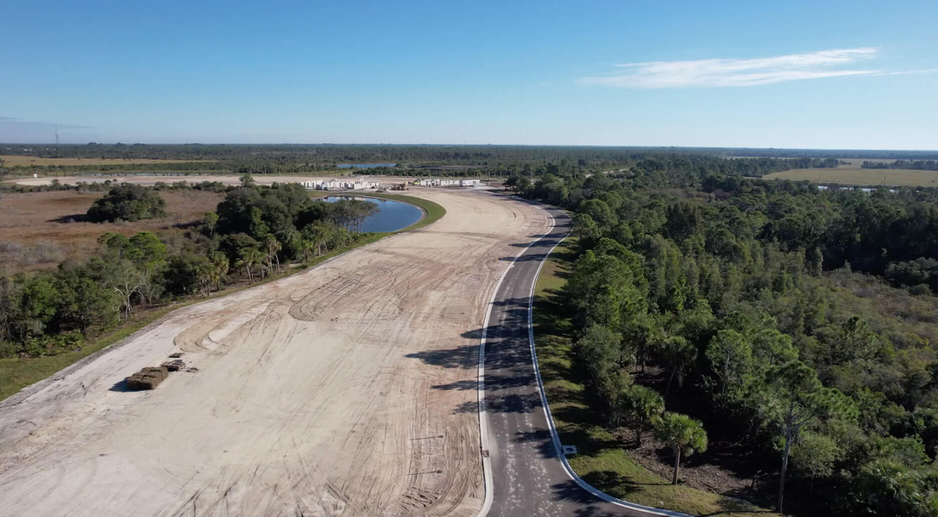 Aerial of new roadway and cleared homesites beside preserve