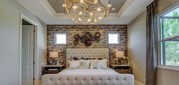 Owner suite with tray ceiling and brick accent wall