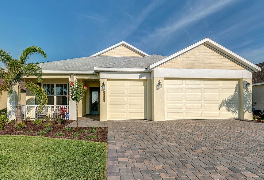 New Sam Rodgers home with front porch and palm landscaping