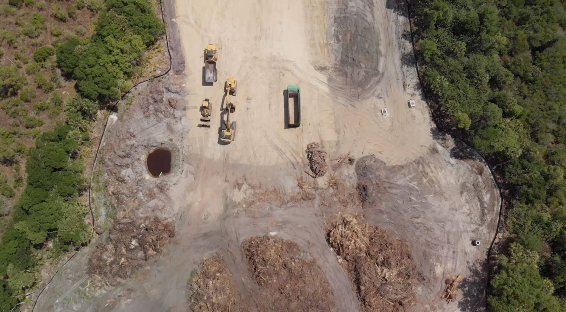 Overhead drone view of site clearing with excavators