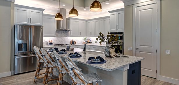 Gourmet kitchen island with brass pendants and granite counters