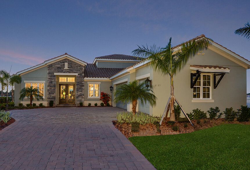 Sam Rodgers model home exterior with stone entry at dusk