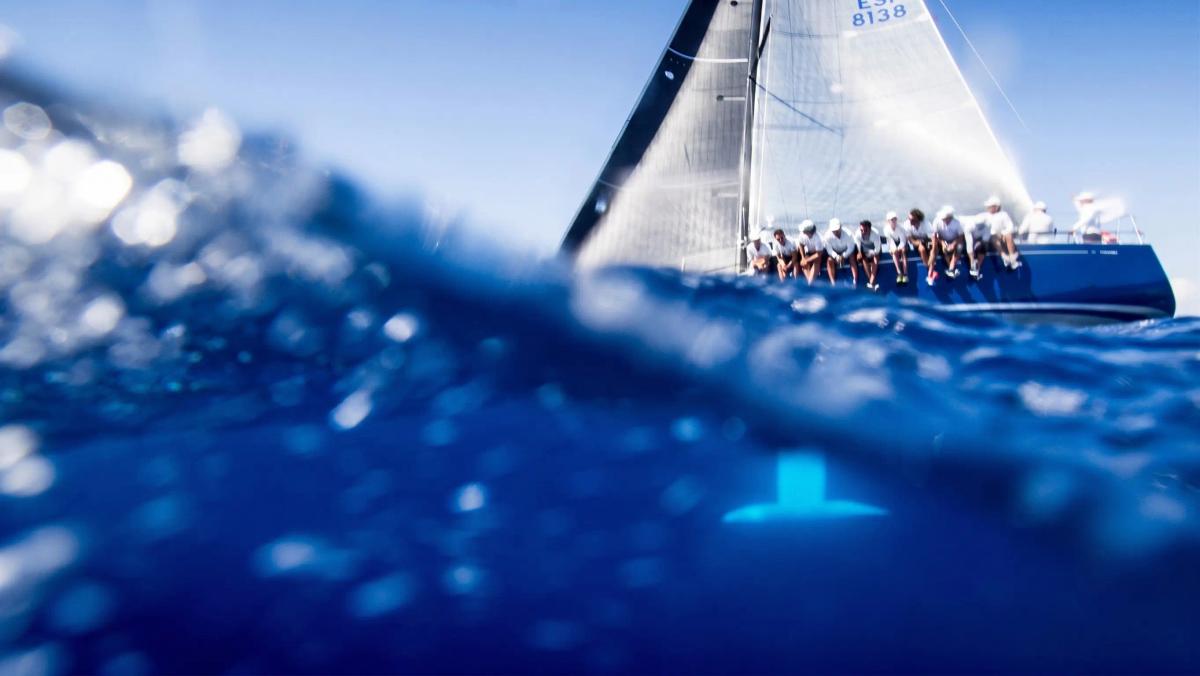 Racing yacht crew hiking out on the rail during a regatta
