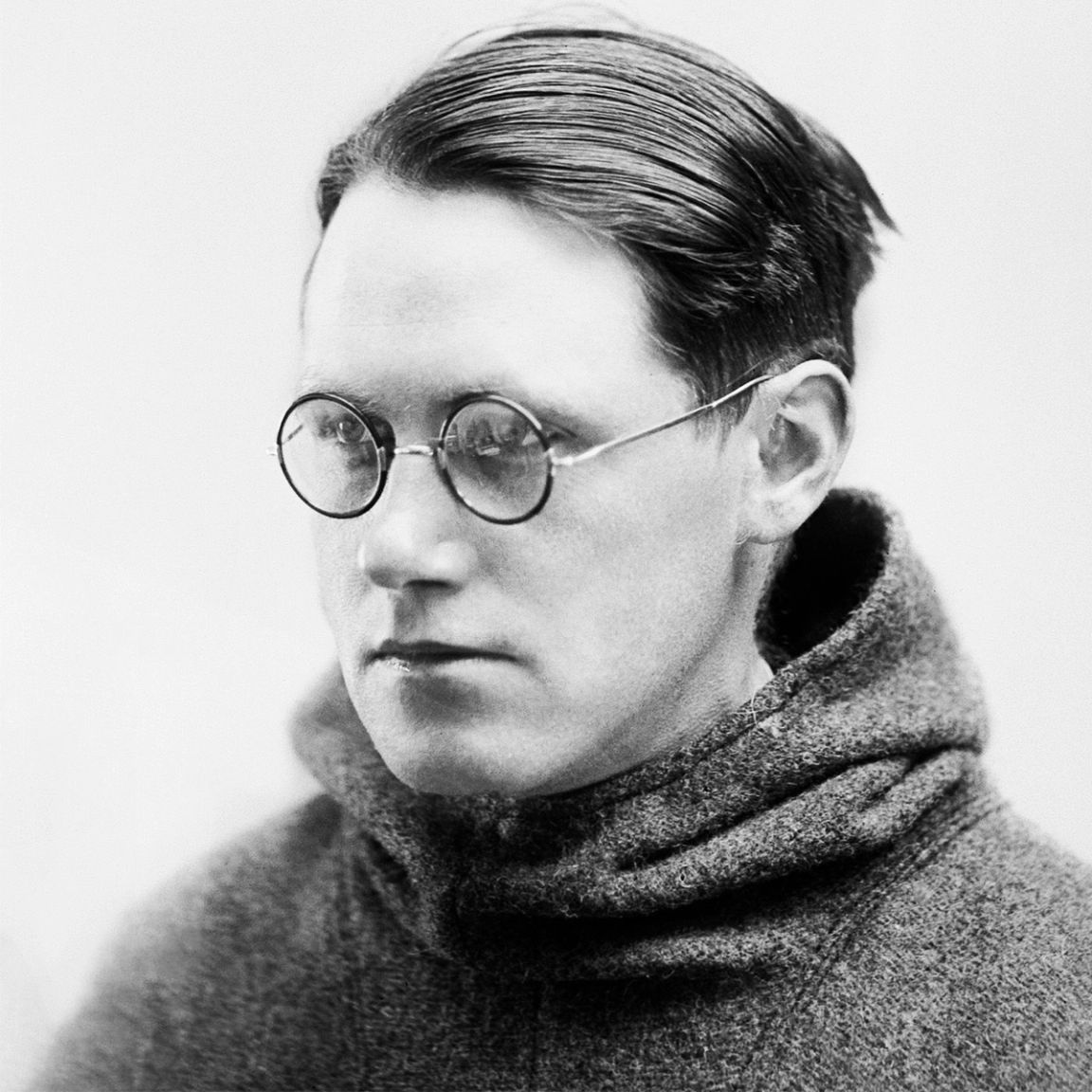 Sort-hvid portrætfoto af Kaj Birket-Smidt iført runde briller og høj turtleneck-sweater