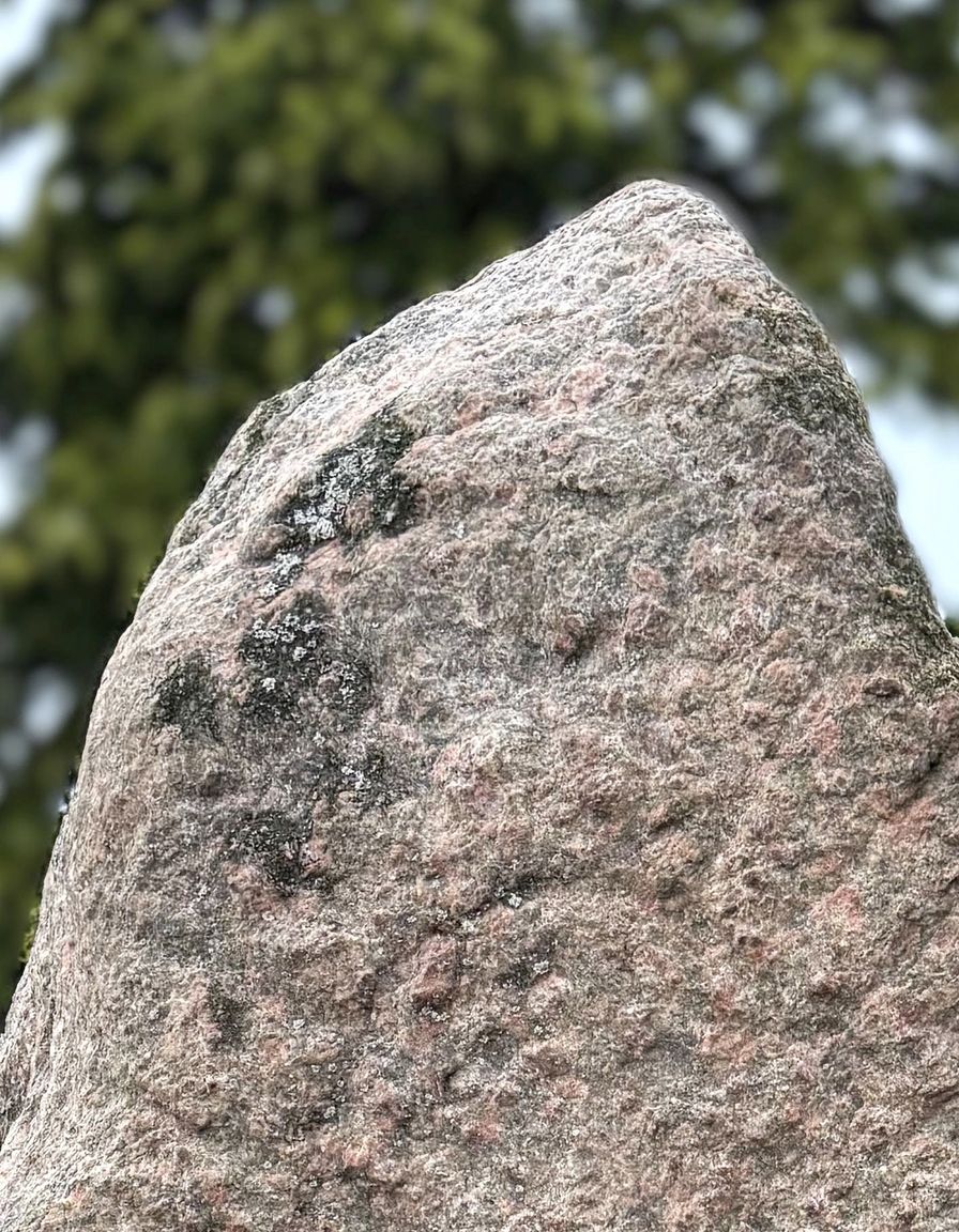 Det øverste af runesten ved Aars Kirke før konservering, der viser hvor snavset og eroderet runestenen er.