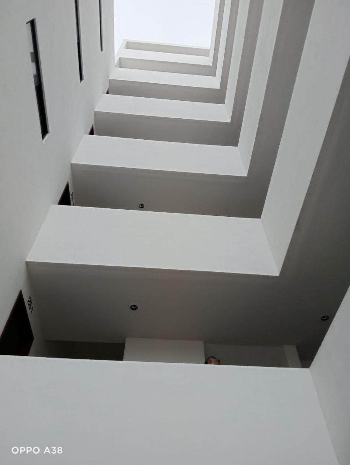 Pozo de luz interior de arquitectura moderna con muros blancos y pasillos rectangulares superpuestos