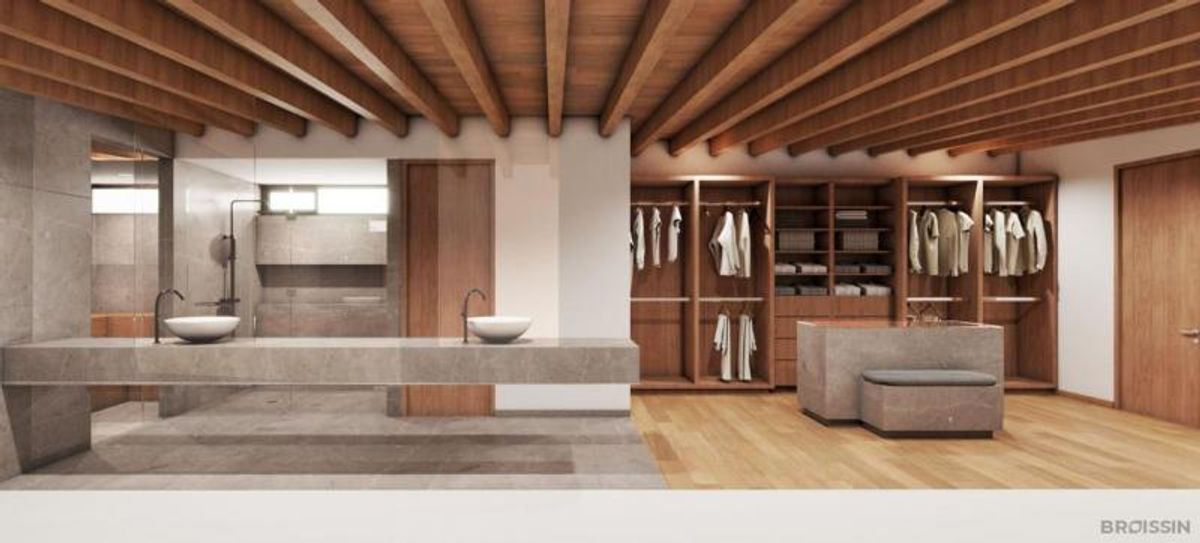 Vestidor y baño con techo de vigas de madera, doble lavabo flotante y clósets de madera