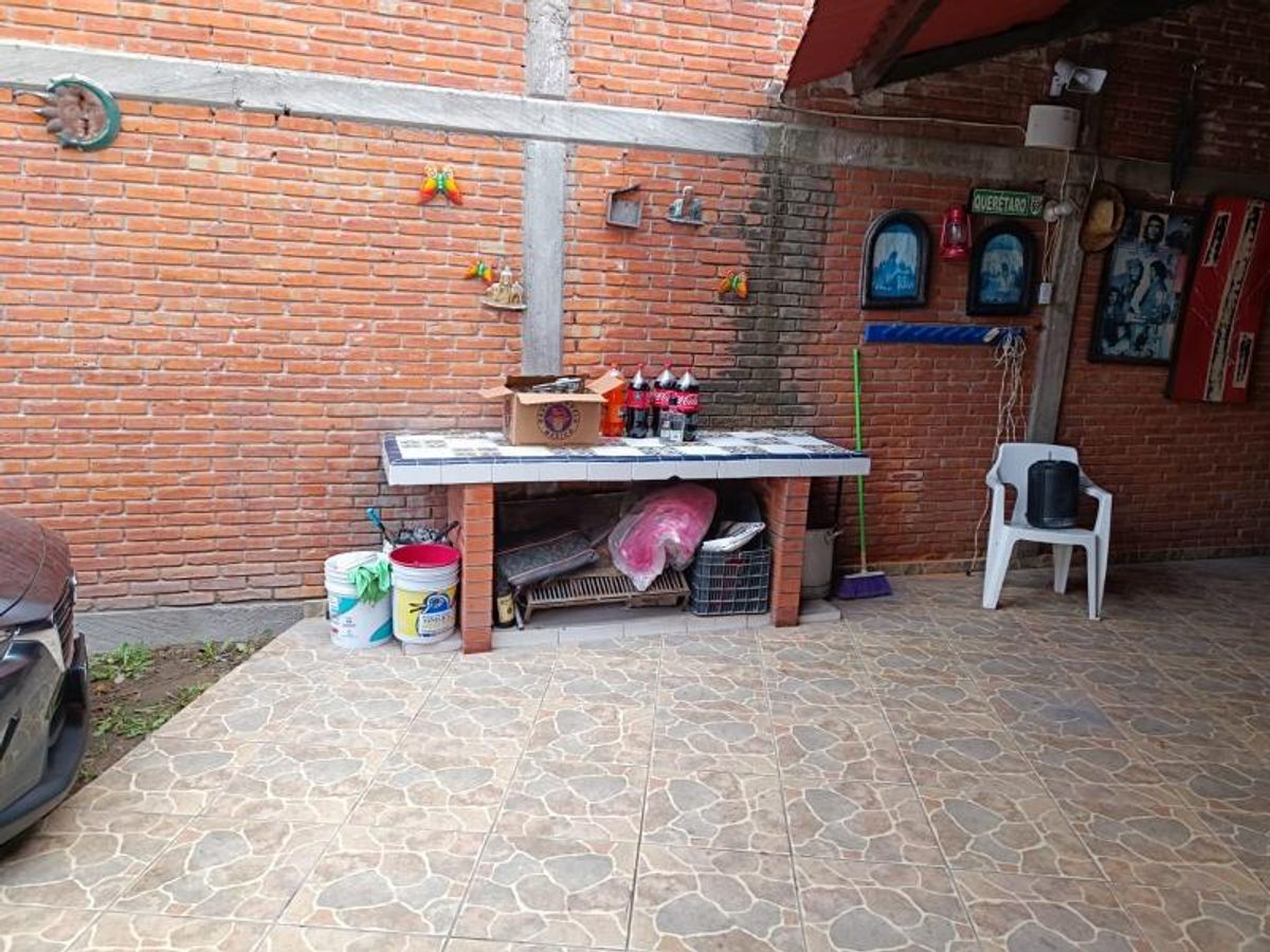 Patio con piso cerámico, paredes de ladrillo aparente y barra de servicio integrada