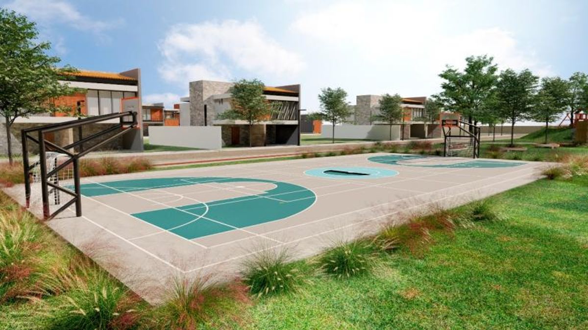 Cancha multideportiva al aire libre rodeada de pasto verde con casas modernas al fondo