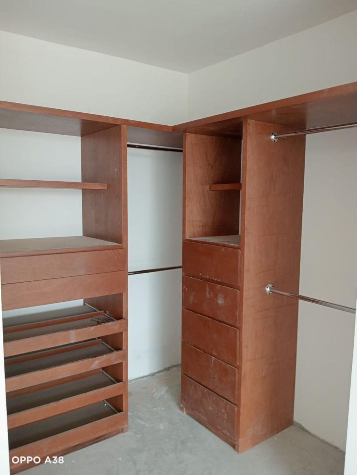 Vestidor de madera con repisas, cajoneras, zapateros y tubos metálicos para colgar ropa