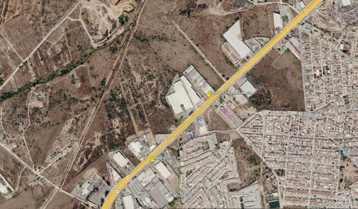 Bulevar trazado en amarillo cruzando una zona con bodegas industriales y fraccionamiento residencial