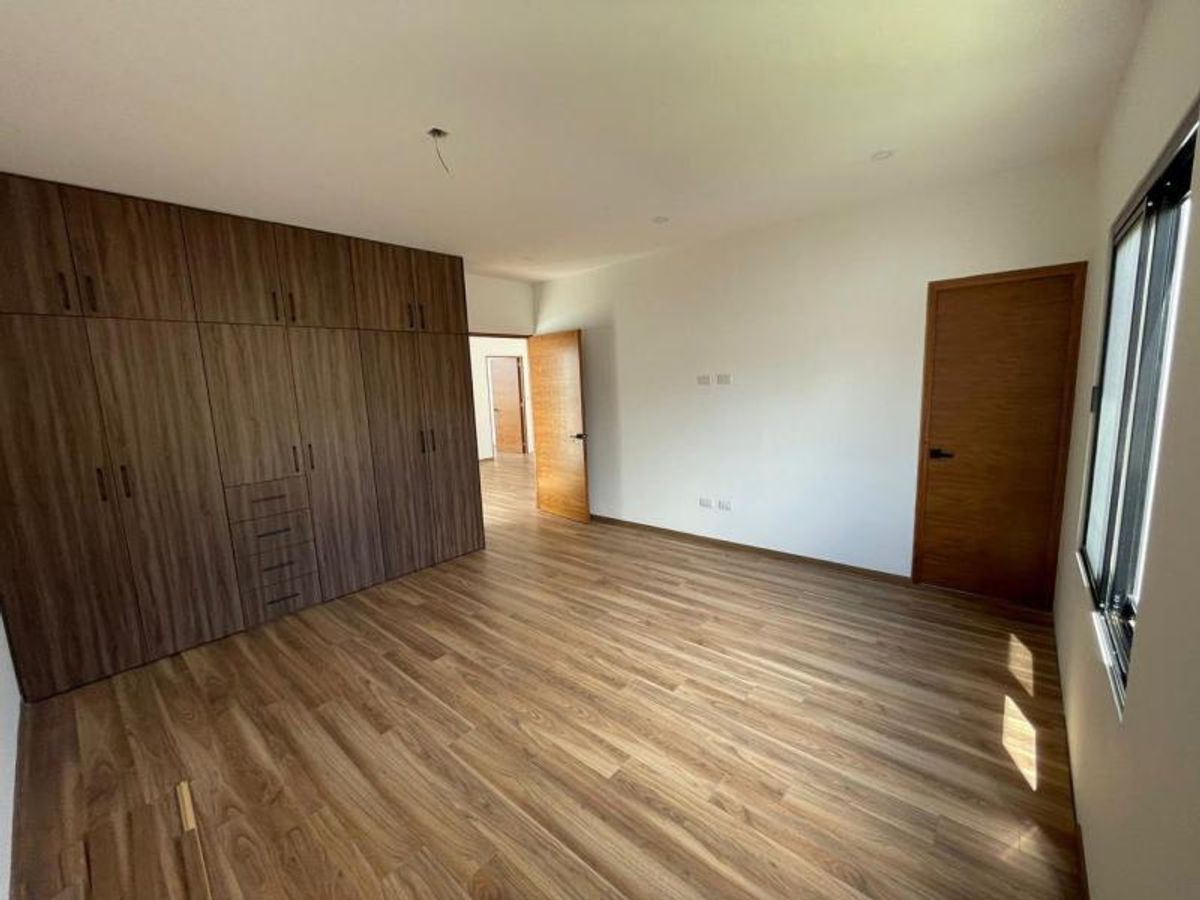 Habitación vacía con piso laminado de madera, clóset empotrado y puertas de madera