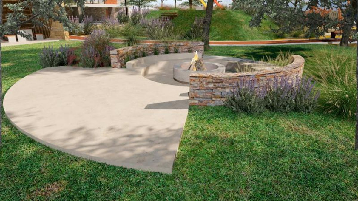 Fogatero circular al aire libre con muros de piedra, patio de concreto y césped