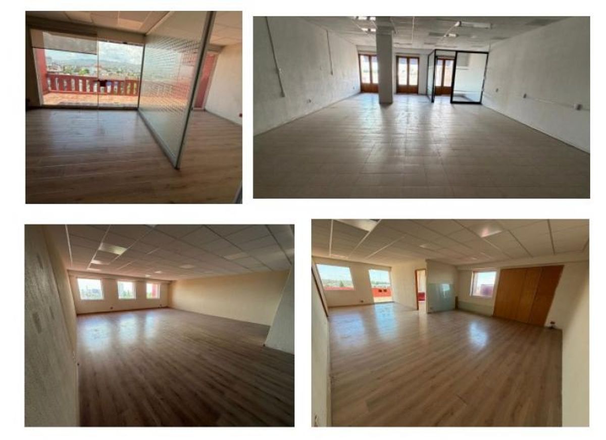 Espacios de oficinas vacíos con pisos laminados, divisiones de cristal y grandes ventanales