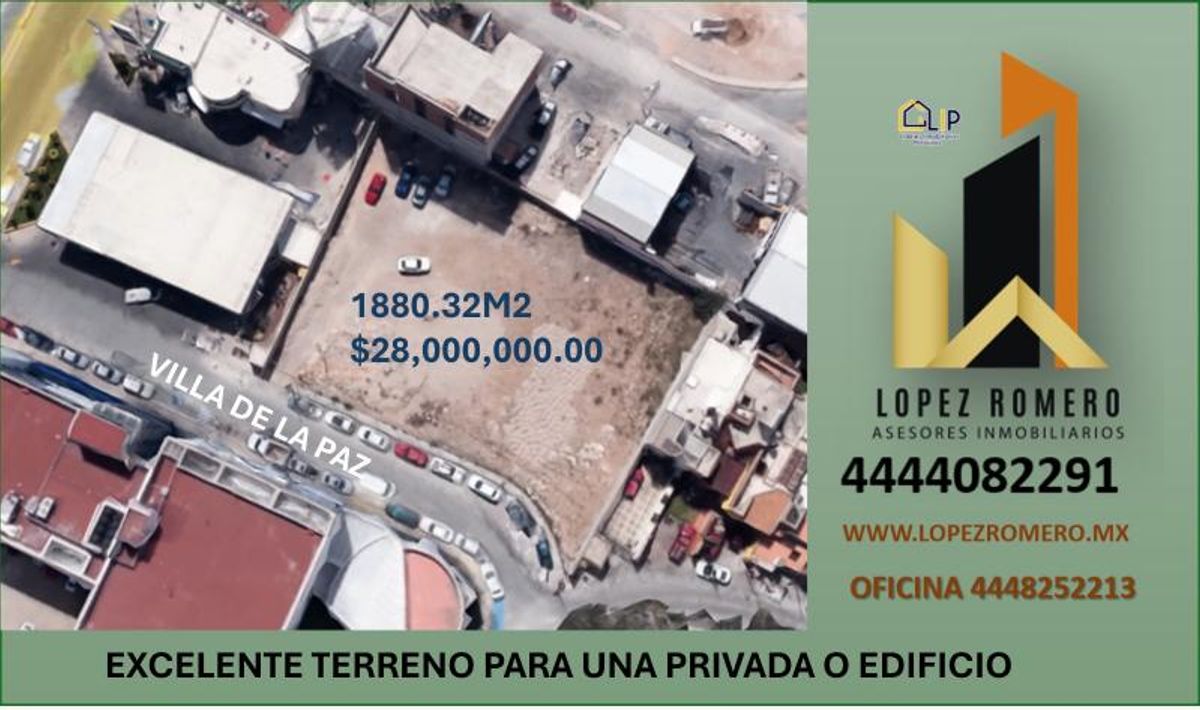Vista aérea de terreno baldío delimitado por edificios urbanos y calle asfaltada con automóviles