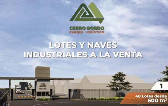 Entrada con caseta de vigilancia y pluma vehicular a parque industrial con naves