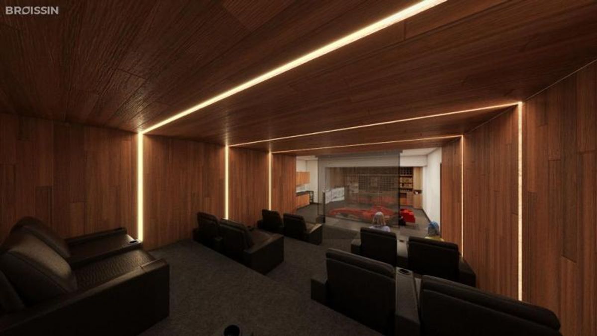 Sala de cine con acabados en madera, iluminación lineal LED y sillones reclinables negros