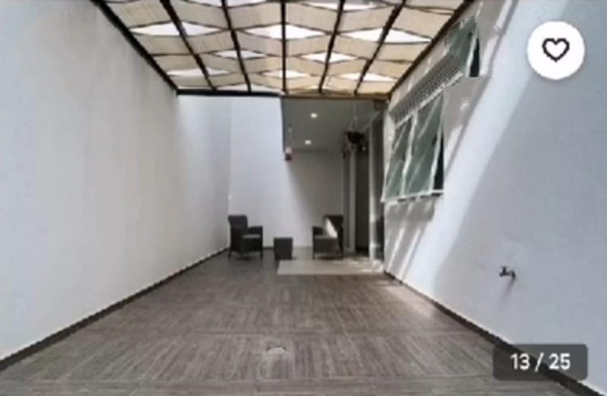 Patio alargado con piso tipo madera, pérgola techada y muebles de exterior al fondo