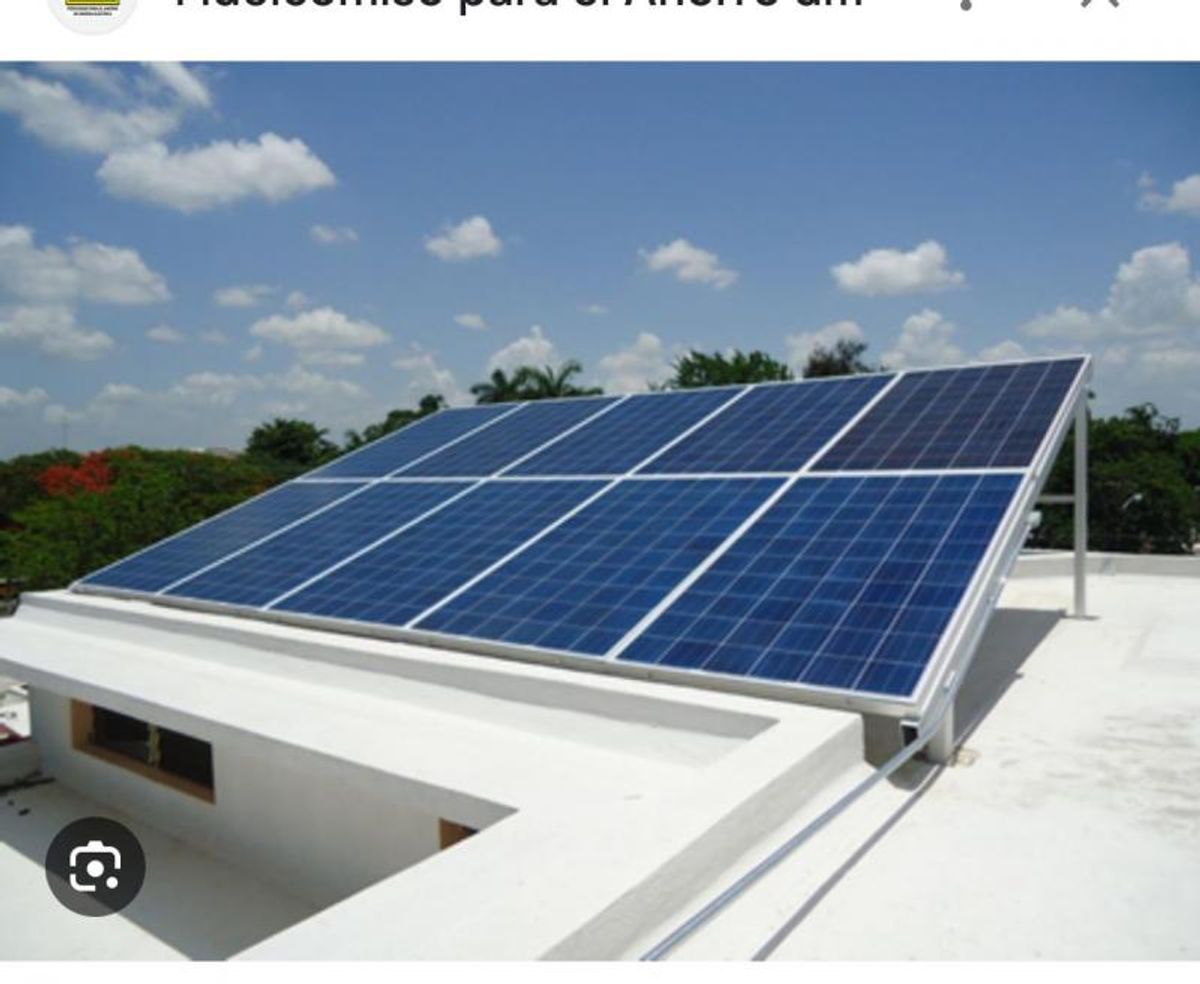 Paneles solares sobre estructura metálica inclinada en la azotea blanca de la casa