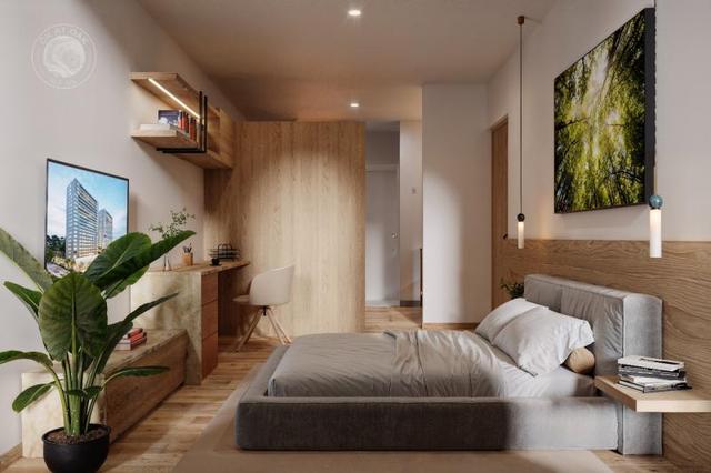 Recámara moderna con cama tapizada gris, escritorio de madera, lámparas colgantes y planta decorativa