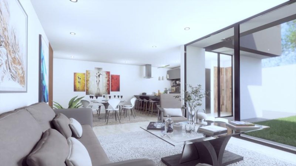 Sala de estar con sofá gris, mesa de cristal, comedor y ventanales al jardín