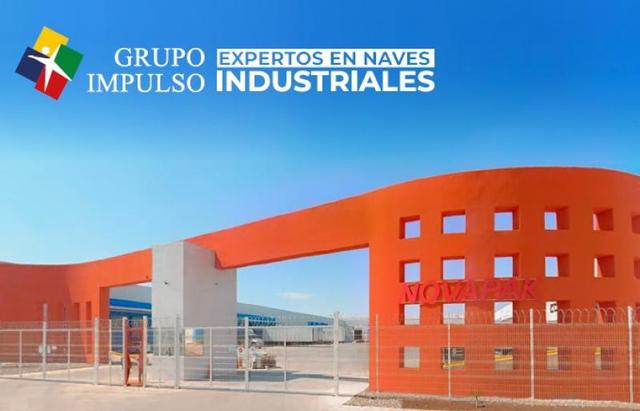 Entrada a parque industrial con estructura curva en color naranja y reja metálica exterior