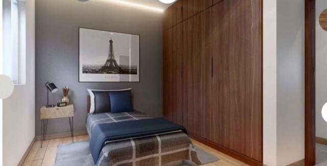 Recámara individual con clóset de madera oscura, cama, mesa de noche y cuadro decorativo