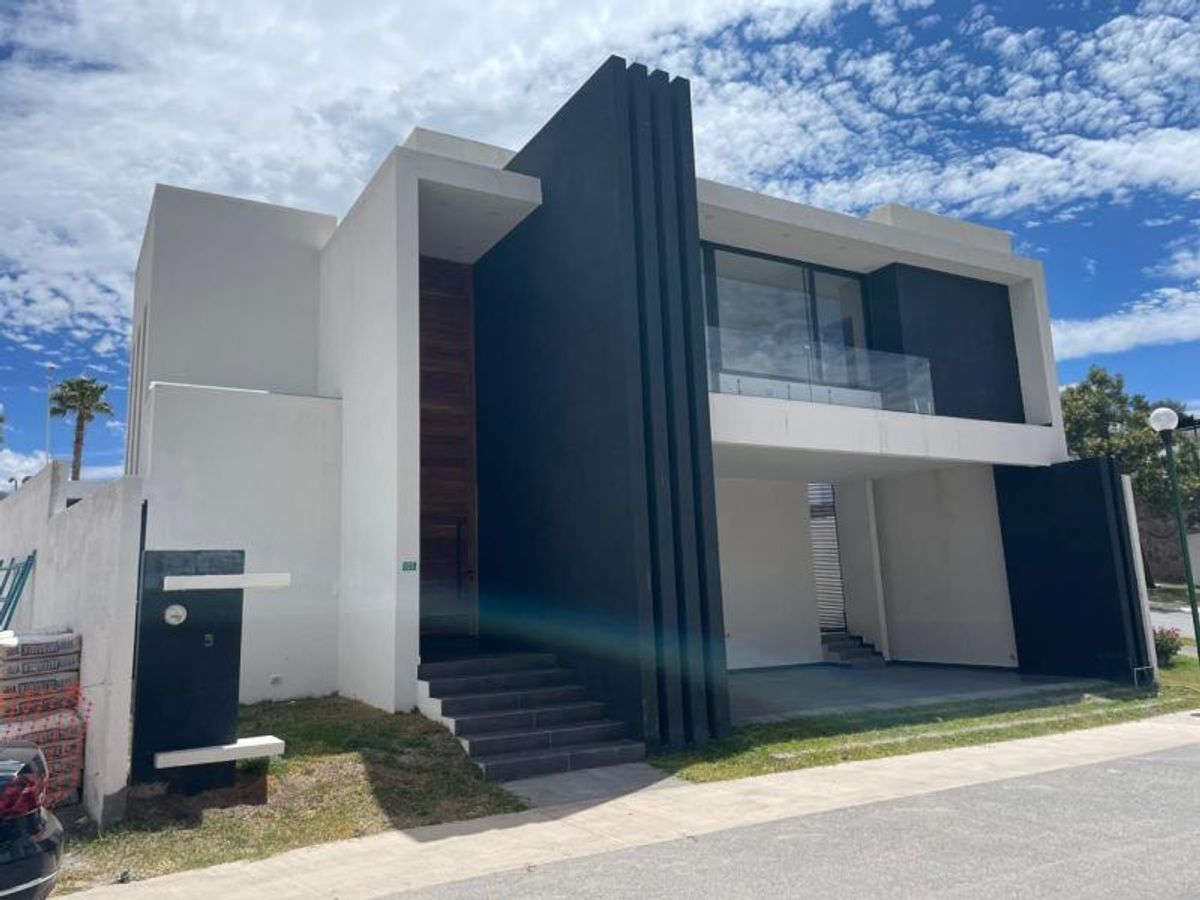Fachada moderna de dos niveles en blanco y negro con puerta principal de madera