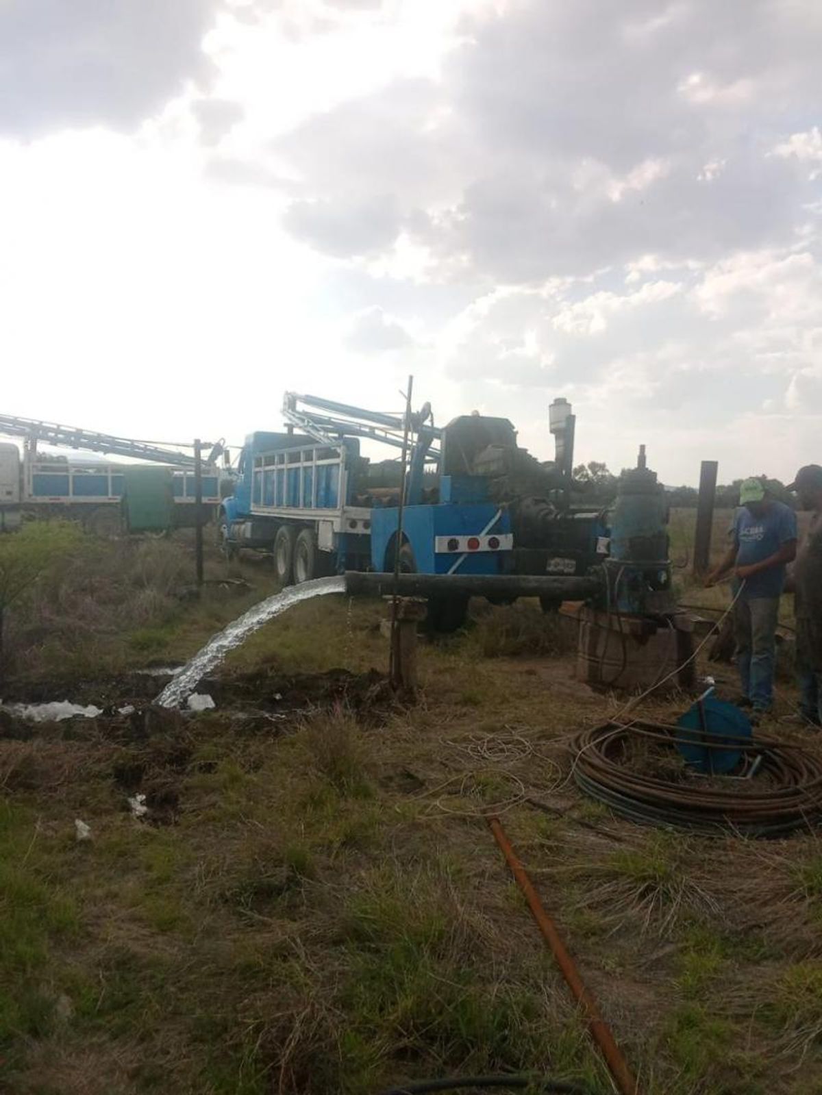 Maquinaria de extracción de agua funcionando en un terreno rústico abierto con pastizal
