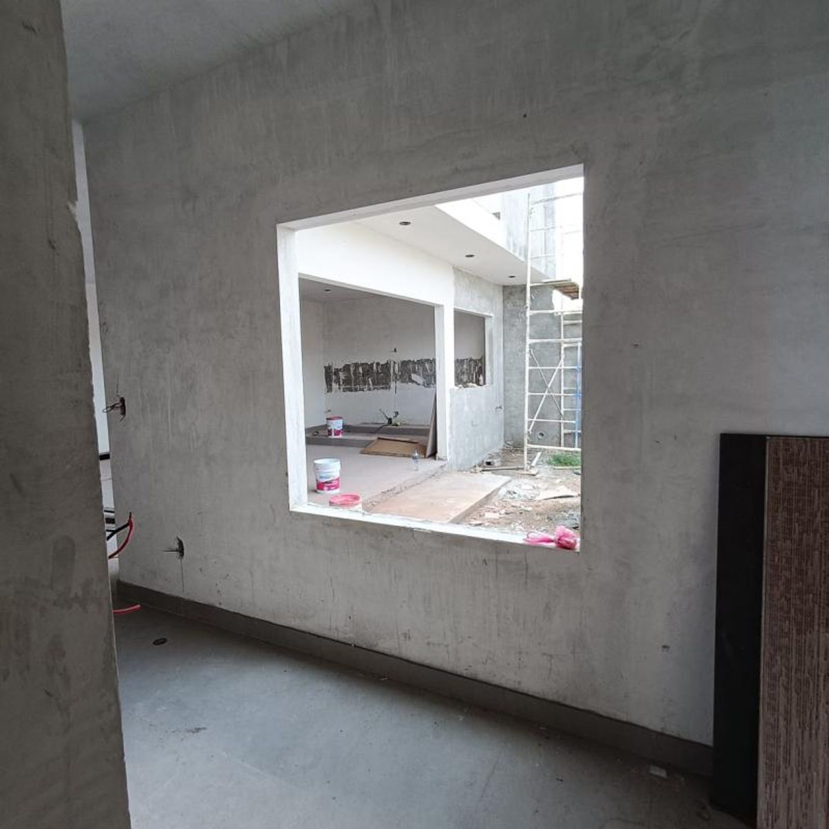 Habitación en obra gris con gran abertura hacia patio en construcción