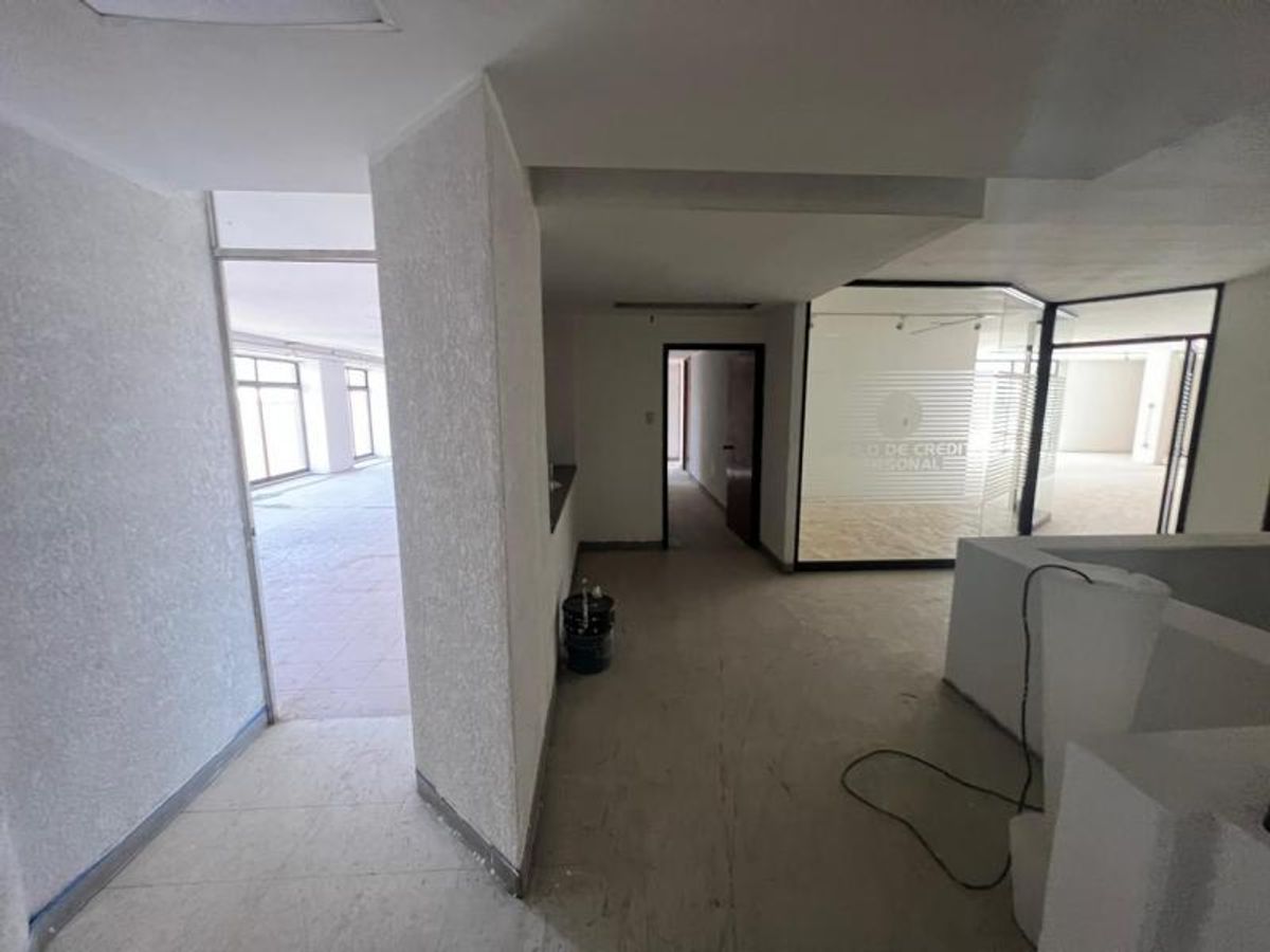 Interior comercial vacío con paredes blancas texturizadas divisiones de cristal y pisos claros