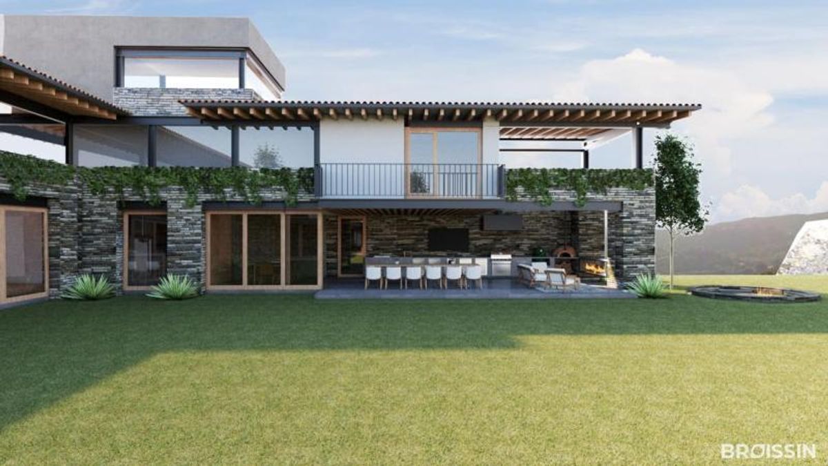 Casa de dos niveles con fachada de piedra, terraza equipada y amplio jardín de césped