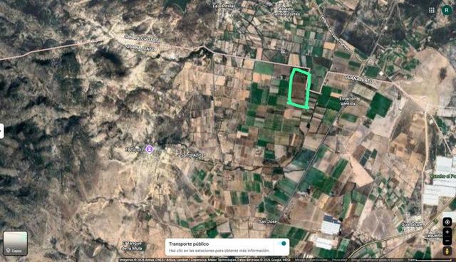 Terreno agrícola delimitado con marco verde rodeado de parcelas de cultivo y zonas montañosas