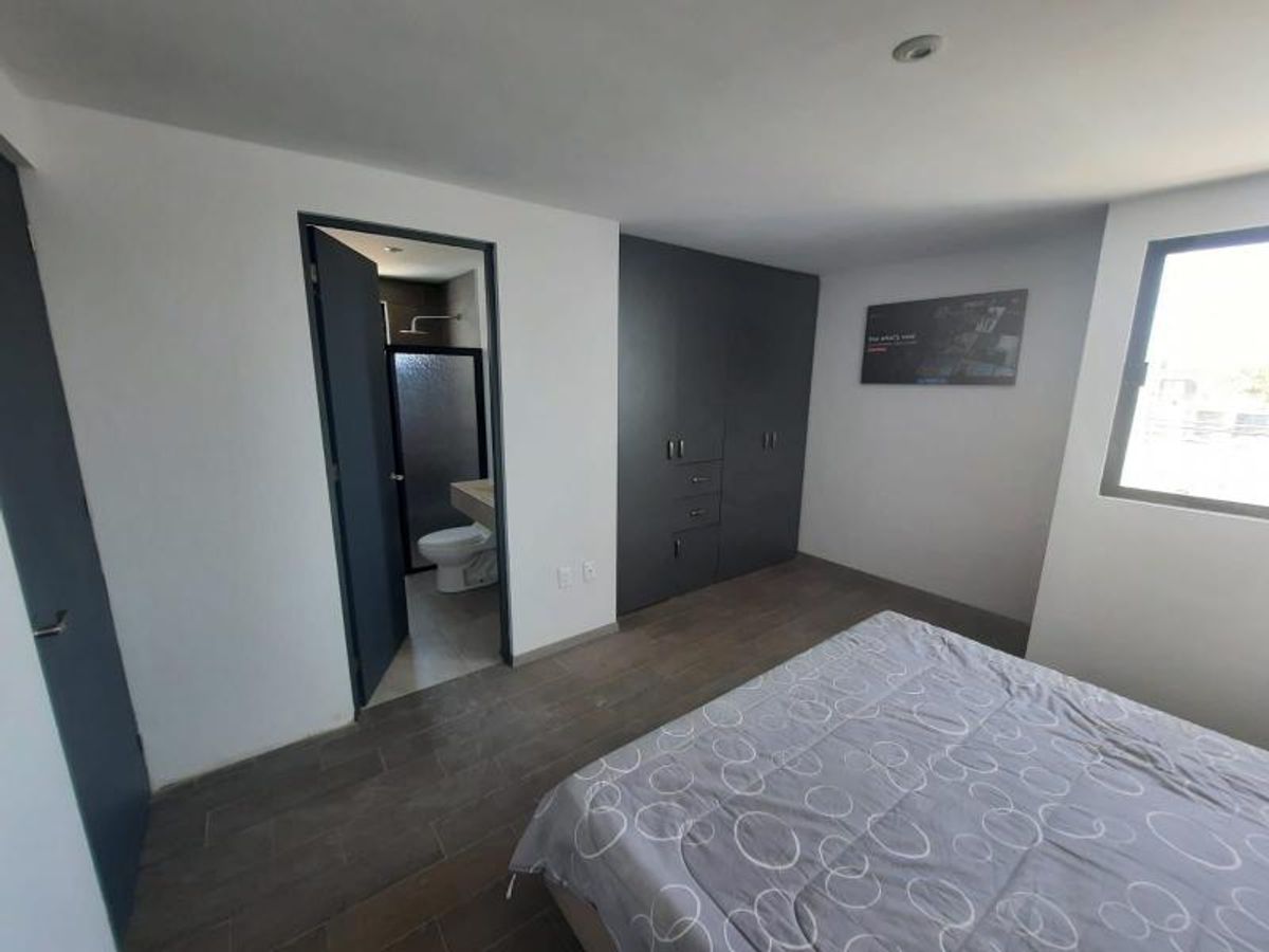Recámara con cama, clóset empotrado gris oscuro, ventana y acceso a baño completo