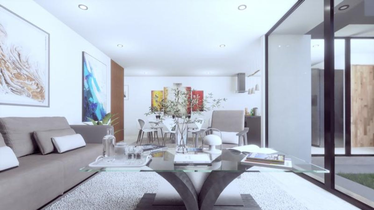 Sala de estar con mesa de centro de vidrio, sofá gris, cuadros y ventanales iluminados