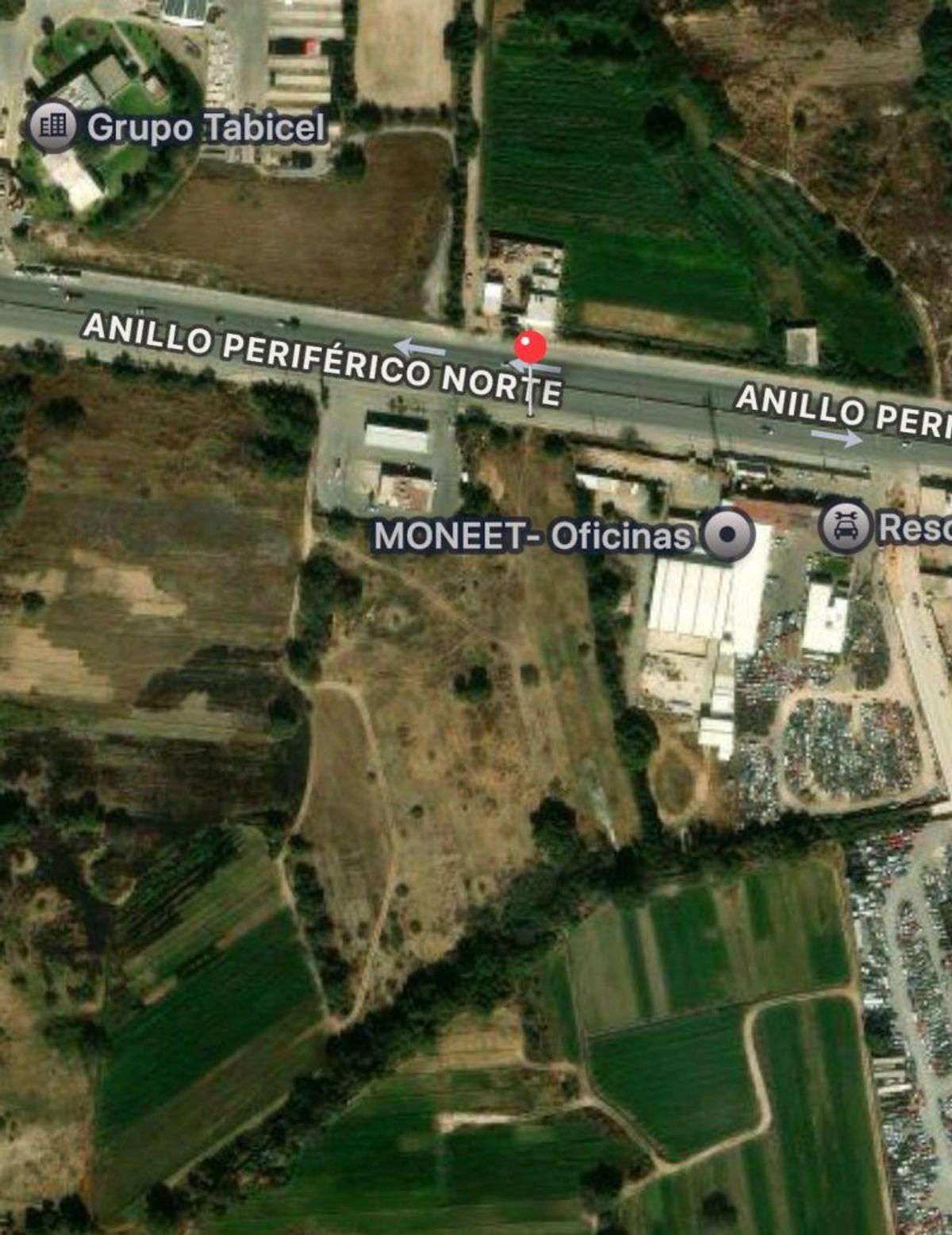 Terreno amplio sobre el Anillo Periférico Norte rodeado por campos verdes y estructuras industriales