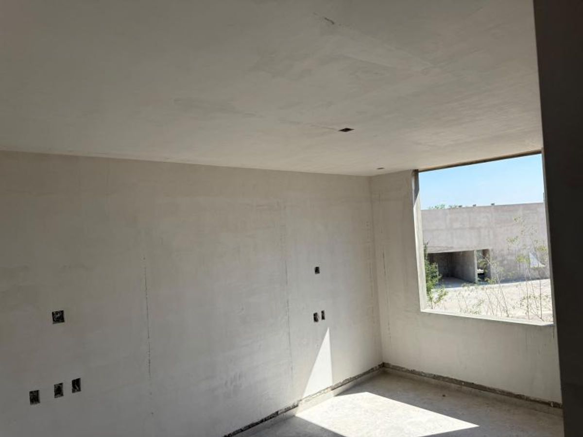 Habitación en construcción con muros enyesados, salidas eléctricas y ventana con luz natural