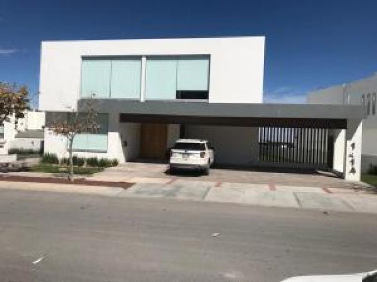 Casa moderna de dos niveles con fachada blanca, cochera techada y camioneta estacionada