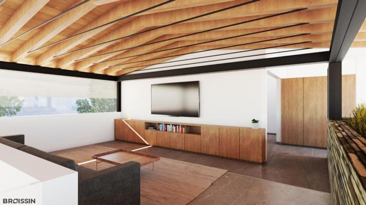 Sala con techo inclinado de madera, televisor sobre credenza de madera y sofá gris