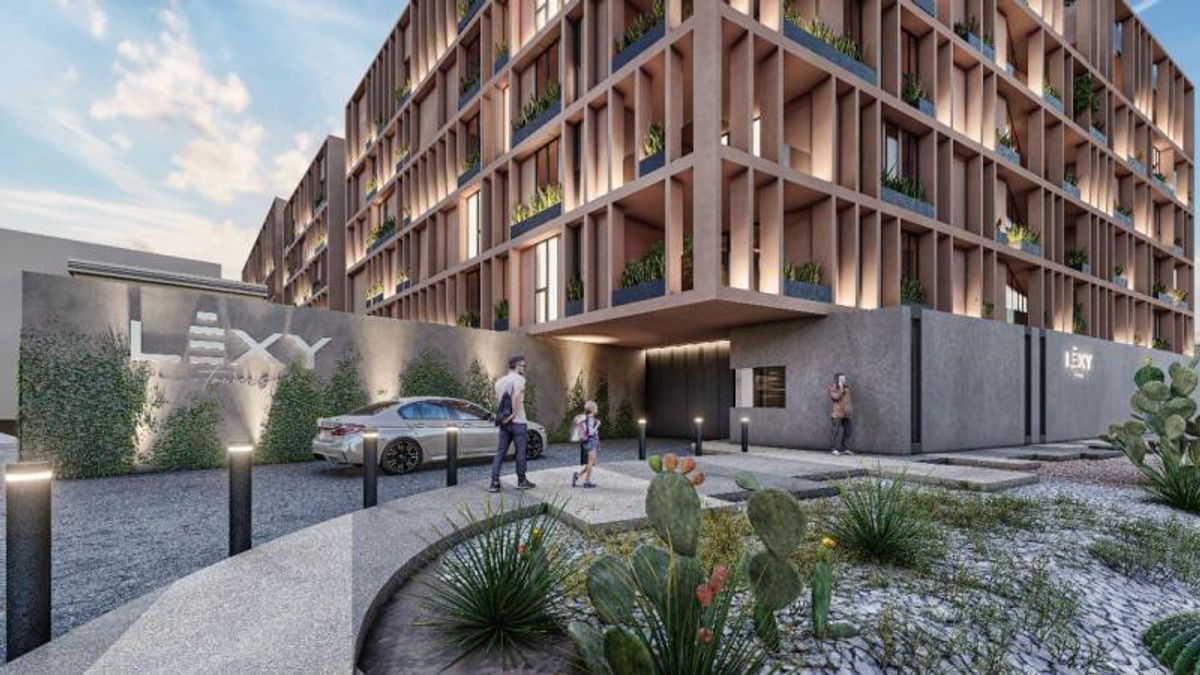 Fachada de edificio residencial con celosías verticales, iluminación exterior cálida y paisajismo desértico