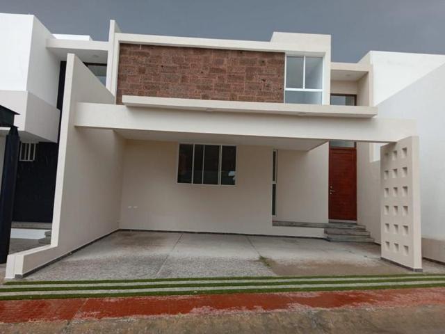 Fachada de casa moderna de dos niveles con cochera techada y muro de piedra