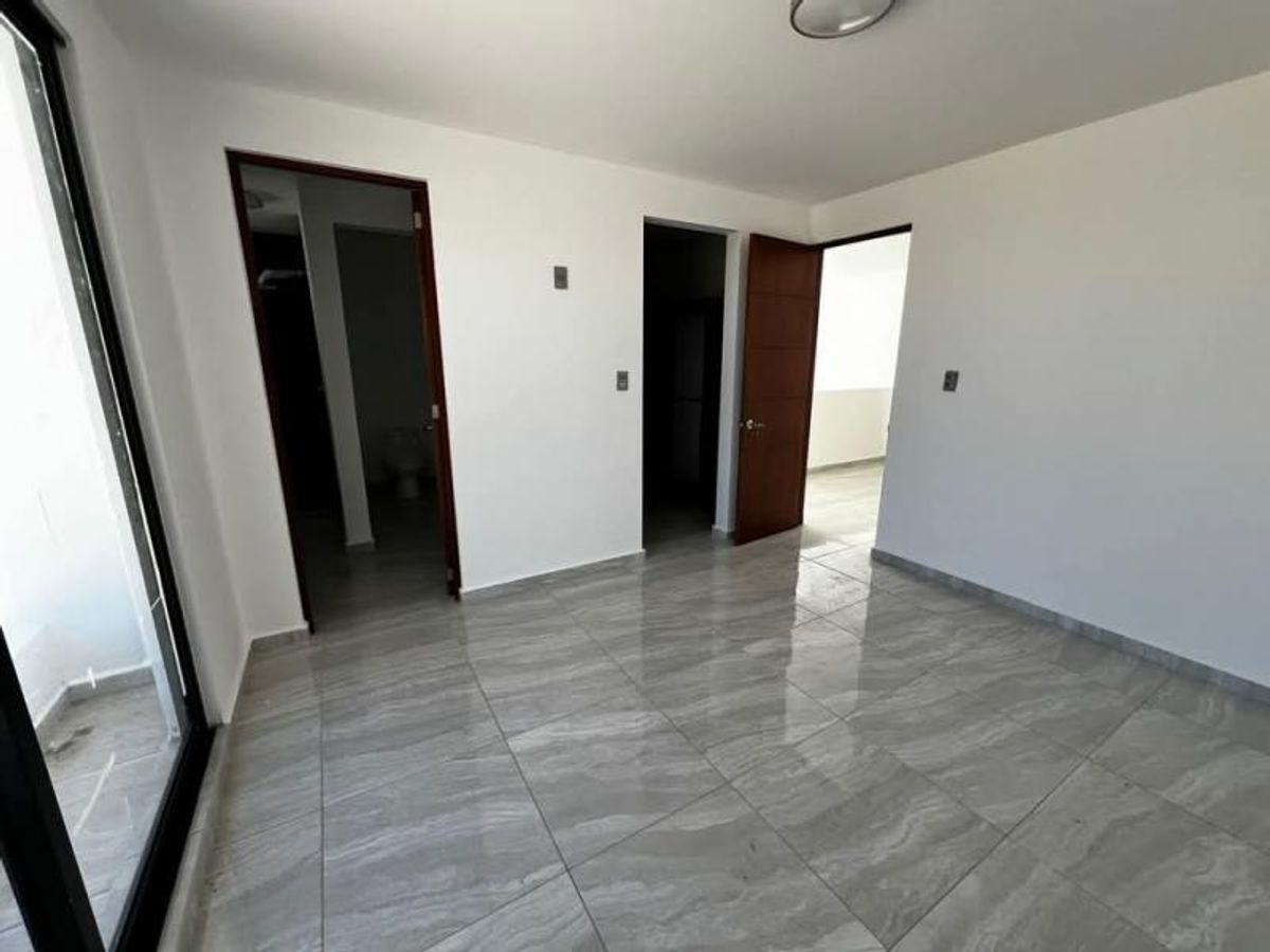 Habitación vacía con piso de porcelanato gris brillante, paredes blancas y puertas de madera