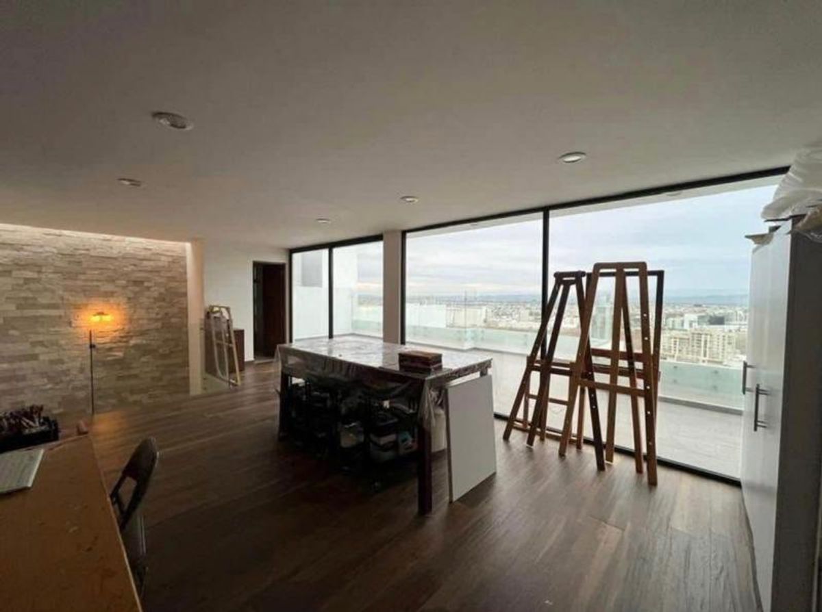 Espacio con piso de madera, ventanales con vista panorámica y muro de piedra