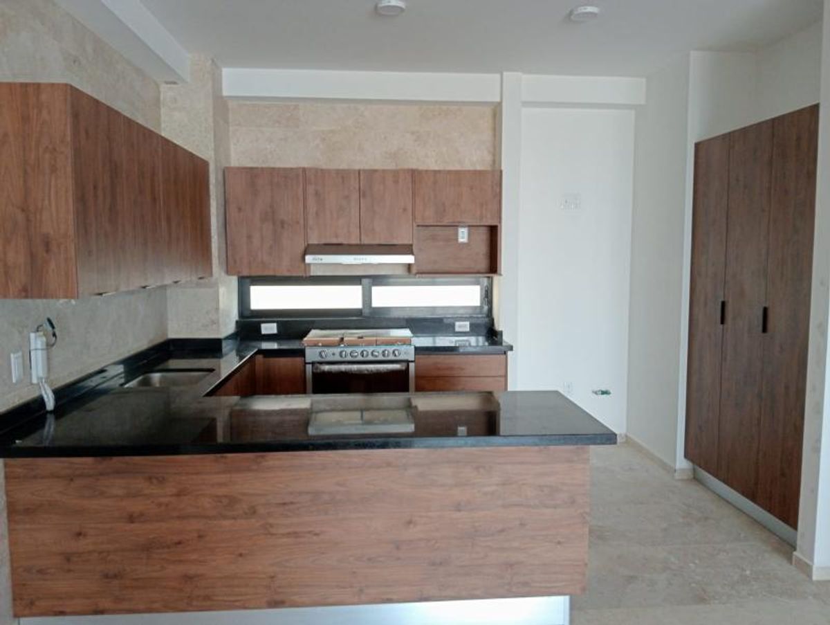 Cocina integral con barra, gabinetes de madera, cubierta de granito negro y estufa