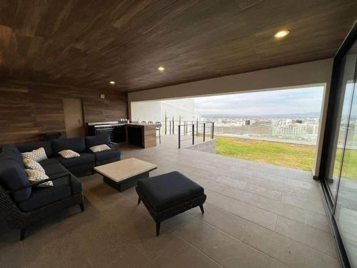 Terraza techada con techo de madera, sala de exterior oscura y vista a la ciudad