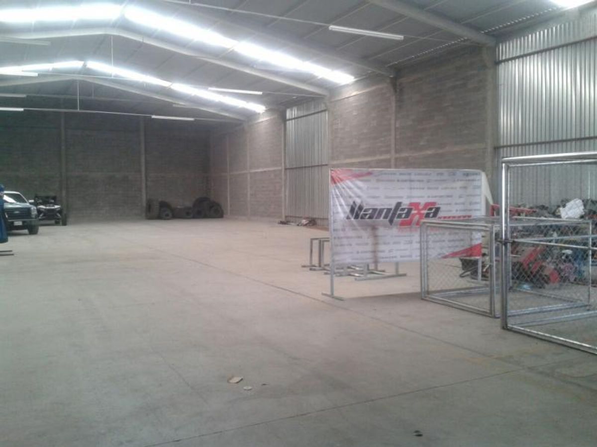 Interior de bodega industrial con piso de concreto, paredes de block y tragaluces