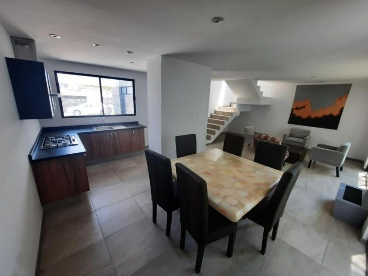 Comedor de seis sillas negras en espacio abierto junto a cocina y sala